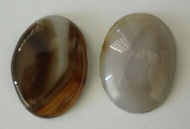 2 cabochons or polished agates - one brown and one white.