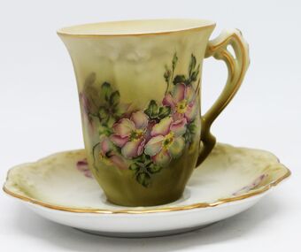 Coffee cup and saucer with hand painted floral design