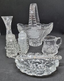 Collection of crystal ware including a basket, salt and pepper shakers, vase, crean jug and a butter dish and knife.