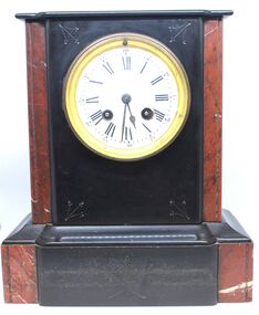 Black and red marble mantel clock featuring round face with Roman numerals