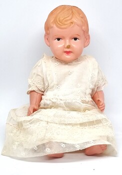 Celluloid doll dressed in homemade white clothes