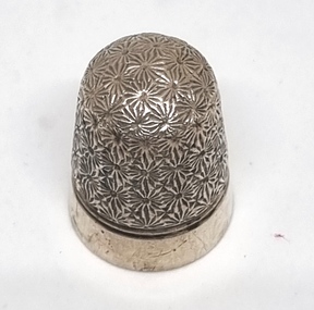 Silver filigree thimble in floral design with plain band around bottom.
