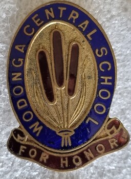 Badge for Wodonga Central School with 3 bullrushes in the centre and the slogan "For Honour"