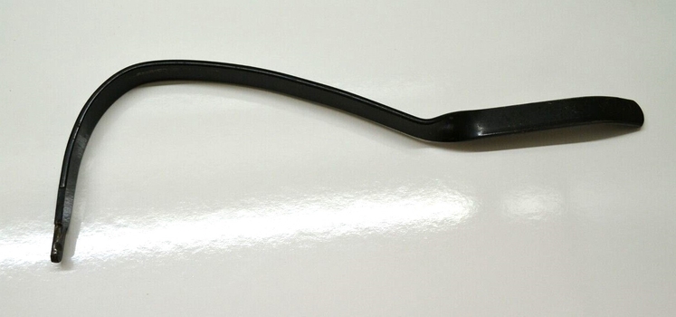 Metal knee bar inserted in hole at front of machine and pressed to adjust speed.