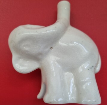 A white ceramic pie funnel in the shape of an elephant.