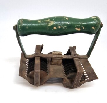 Metal and wood rollet used to cut herbs before cooking.
