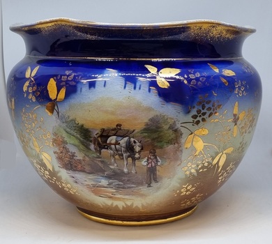 Large decorative ceramic bowl with rural scenes and gilt decoration