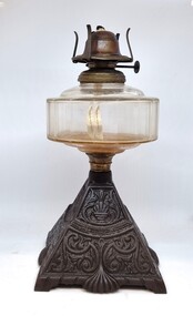 A kerosene lamp with cast iron decorative base