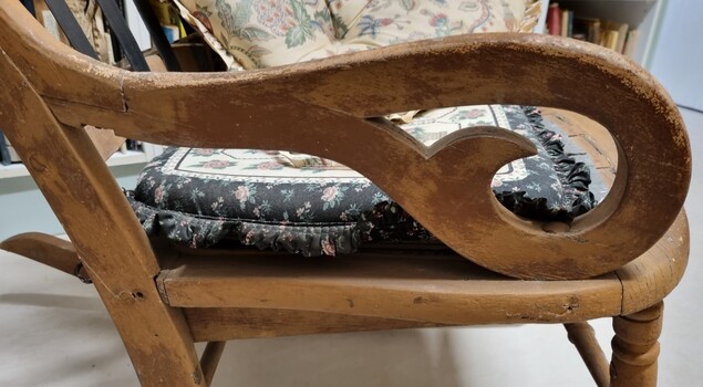 Side view showing carved armrest