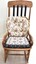 An old rocking chair with 2 cushions attached