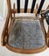 The chair seat showing extensive wear and repairs to back.