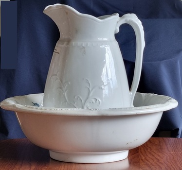 White ironstone china bowl and jug with leaf design on jug.