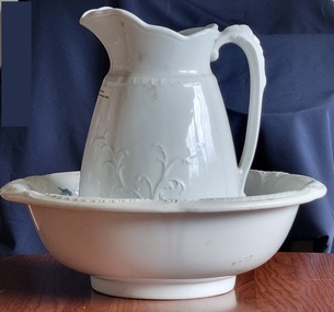 White ironstone china bowl and jug with leaf design on jug.
