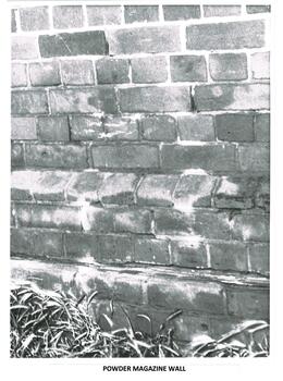 Brick wall of the Powder Magazine showing cracks and wear.