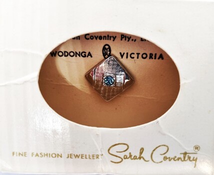 Tin pin in  packet with clear central window and Sarah Coventry logo