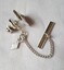 Tie pin showing chain and clip including diamond shape tag labelled "SarCov"
