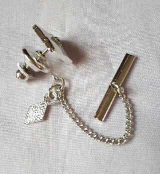 Tie pin showing chain and clip including diamond shape tag labelled "SarCov"