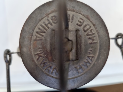 Top view embossed with "Made in China "Kwang Hua" and with a small handle attached.