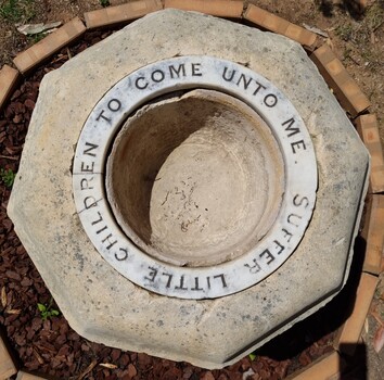 Hewn stone font top view with inscription