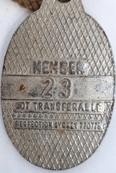 Rear of badge showing member number and maker's mark.