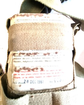 Chemical tank held in khaki webbing strap harness