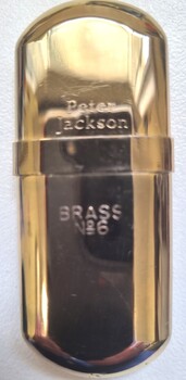A gold cigarette lighter engraved "Peter Jackson Brass NO. 6"