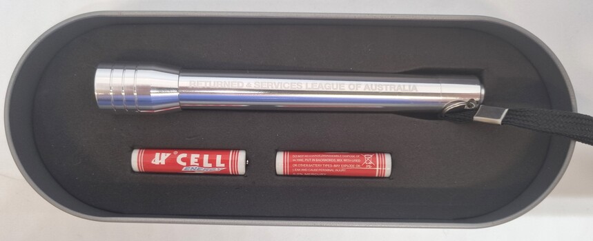 Small aluminium torch and 2 batteries inside foam insert in tin