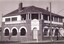 Brick building with white window casements and balcony upstairs