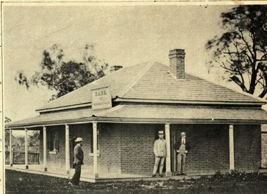 3 gentleman standing on the verandah in front of a brick building