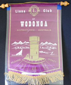 A small purple and gold banner with gold fringe trim