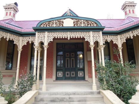 Main door with ornate ironwork along verandah.