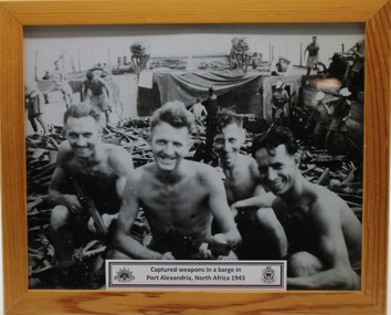 Photograph three soldiers working on a barge in Port Alexandra North Africa 