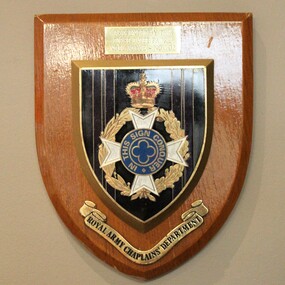 Wooden plaque, light coloured timber with small engraving plate and large insignia of Royal Army Chaplains' Department.