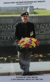 Colour photograph in portrait mode with Trooper Welsh holding a wreath