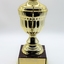 Trophy gold in color sitting on dark colored plastic stand.