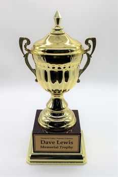 Trophy gold in color sitting on dark colored plastic stand.