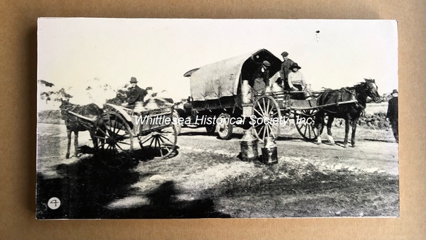 Transferring milk cans to motor lorry at Wollert for cartage to Melbourne 1921
