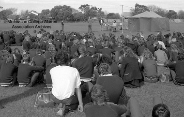 Photograph, 1980 Mordialloc-Chelsea High School School Sports Day - students listen to announcements on the back oval