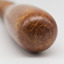 The rounded end of a golden coloured wooden baton