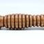The grooved handle of a golden coloured wooden truncheon