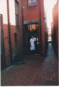 Photograph - Shop assistant of No. 112 Maling at the back door of shop, Jan Pigot, 27/03/1993 12:00:00 AM
