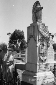 Photograph, Marjorie (Myers) Butler standing next to Henry Myers gravestone, 1992