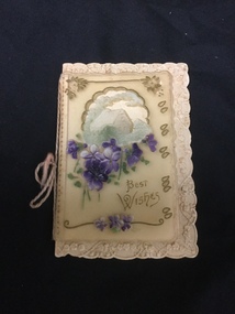 A Best Wishes card with a celluloid overlay showing a house, violets and the message.