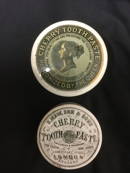 Round dentifrice box with "Cherry Toothpaste Patronized by the Queen" on the lid, and  "Cherry Toothpaste, London England" inscribed on the  base.
