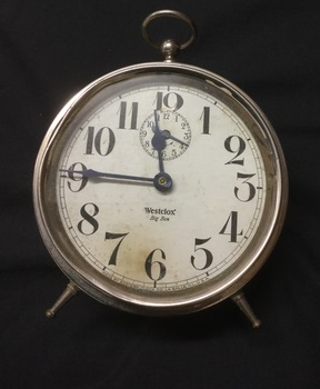 Clock with round white dial and black numerals. "Westclox" inscribed on dial.