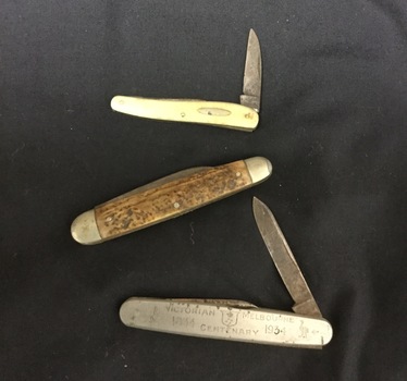Three pocket knives. 1. Bakelite handled knife with engraving plate. 2. Metal handled knife with engraving plate. 3. Steel pocket knife. Centenary 1834-1934. Made for Victorian Melbourne Centenary.