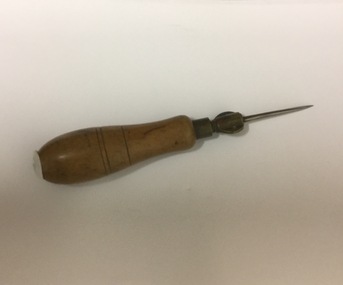 Hole punch for use with leather - has needles inside. Wooden handle, metal hole punch on end.