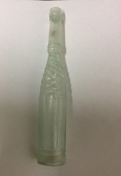 Opaque long neck bottle with etched, twisted pattern.