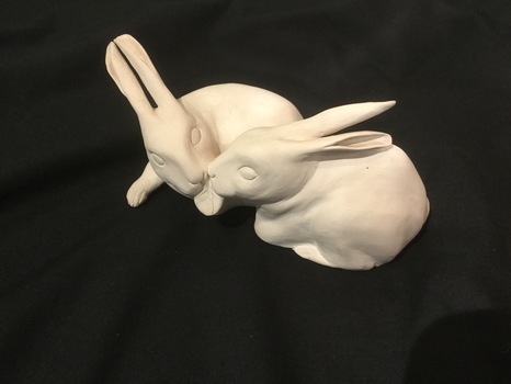 Pair of white, joined pottery rabbits - eating a leaf.