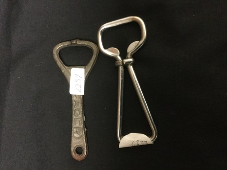 Two cast iron bottle openers, rusted exterior. 